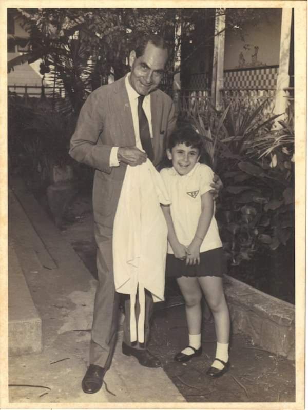 Cristina Caetano, de uniforme de jardim de infância, com o pai. (foto gentilmente cedida por Cristina Caetano)